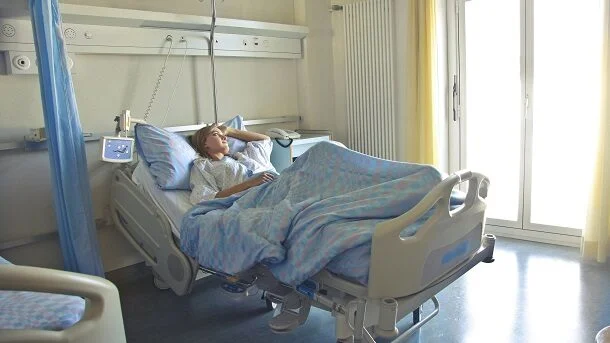 Pacient într-un pat de spital