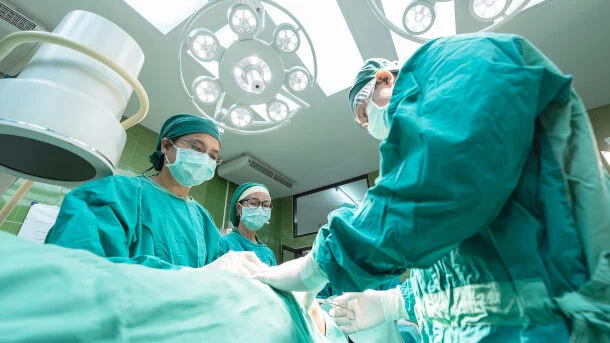 Pacient și trei doctori într-o sală de operații