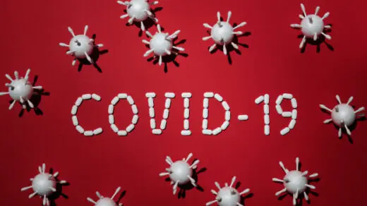 Covid-19 pe un fundal roșu înconjurat de simboluri de viruși biologici
